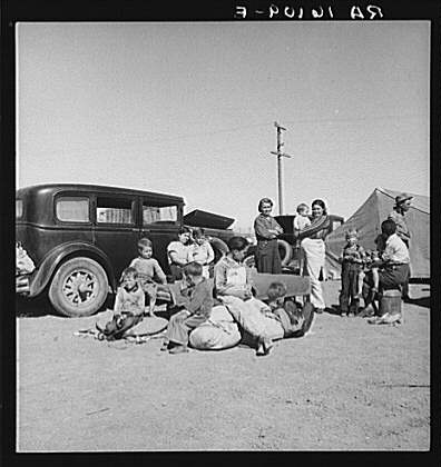 Four families, three of them related with fifteen children, from the Dust Bowl in Texas in an overnight roadside camp near Calipatria, California